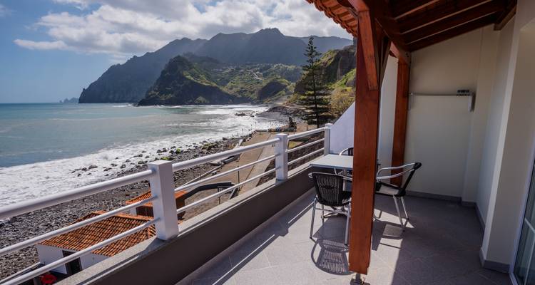 View of coastline from a balcony with mountains.