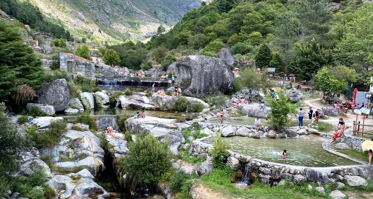 Piscines naturelles entourées d'un paysage rocheux et de personnes.