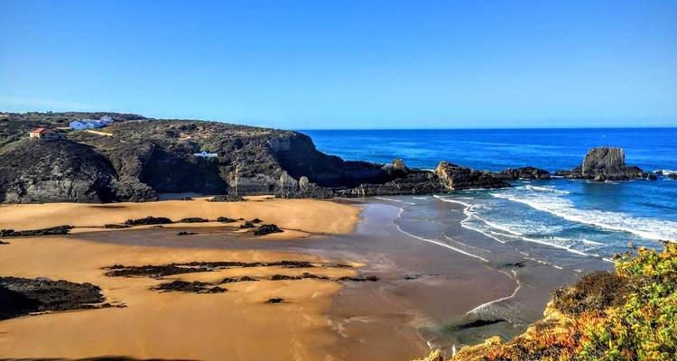 Plage isolée avec des eaux claires et des falaises.