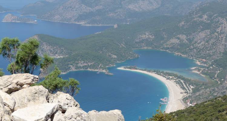 Aerial view of a coastal bay with lush greenery and rocky hills.