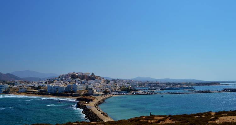 Mer ouverte avec une ville sur une péninsule visible au loin.