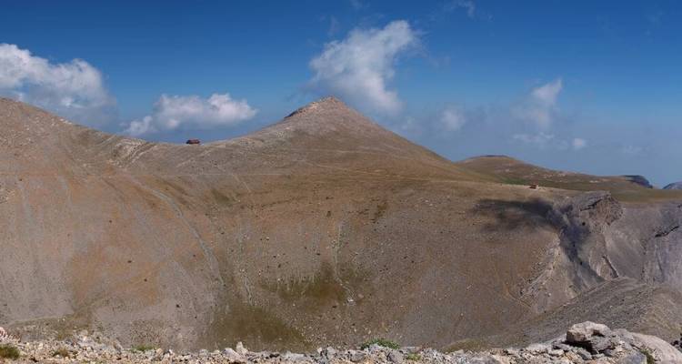 Barren mountain ridge against a blue sky.
