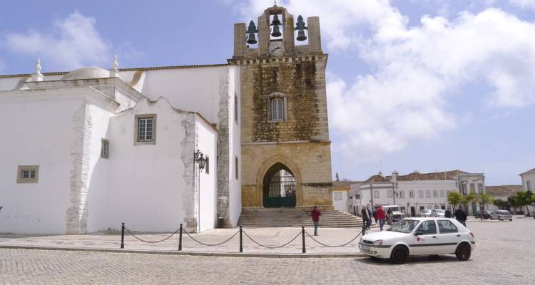 Bâtiment historique avec clocher sur une place publique.