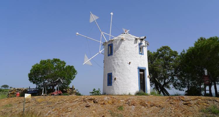 Un moulin à vent blanc traditionnel sur une colline.