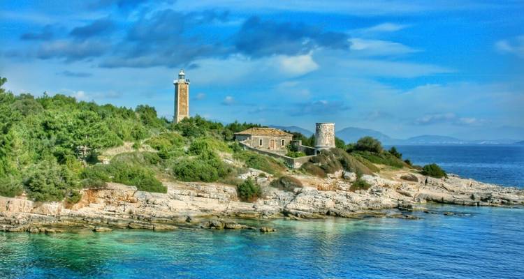 Lighthouse and fort-like structure on a rocky shore.