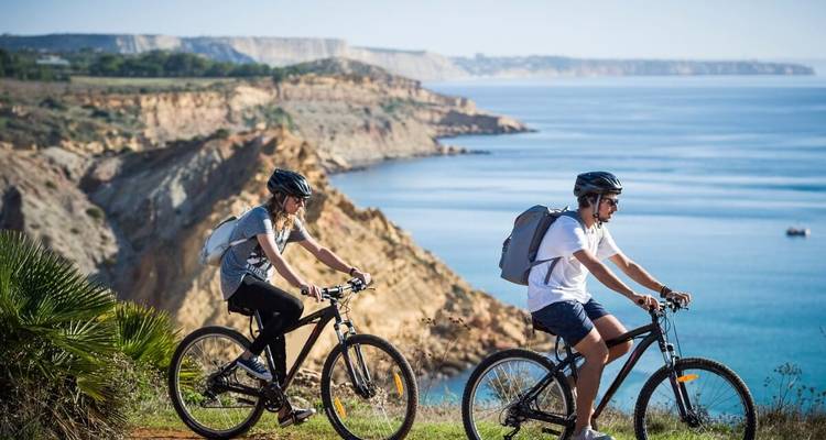 Deux cyclistes roulant le long d'un sentier côtier.