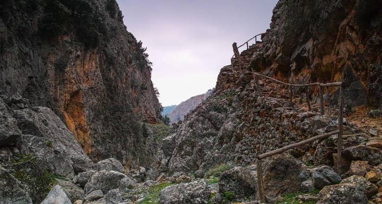 Sentier de canyon rocheux avec une balustrade d'un côté.