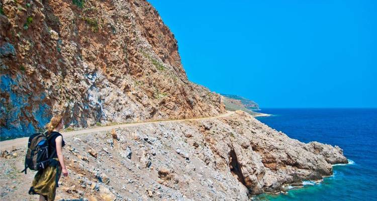 Randonneur marchant le long d'un sentier de falaise côtière.