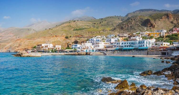 Ville côtière aux bâtiments blancs au bord de la mer.