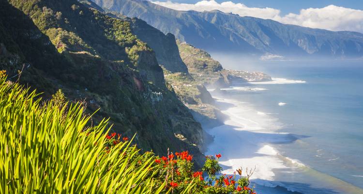 Vue panoramique d'un littoral avec des falaises et des vagues déferlantes.