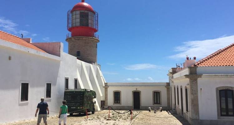 Leuchtturm mit Touristen an einem sonnigen Tag.