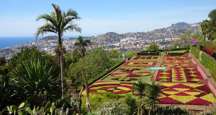 Garden with geometric patterns overlooking city.