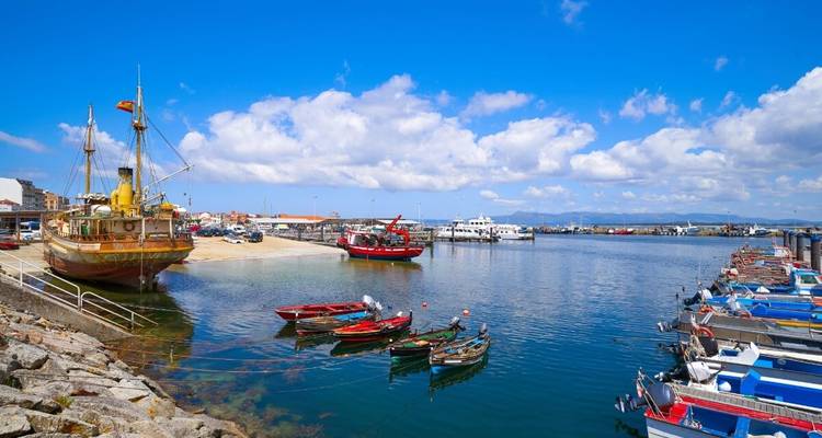 Port avec des bateaux colorés et un navire historique.