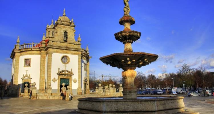 Église historique et fontaine sur une place.