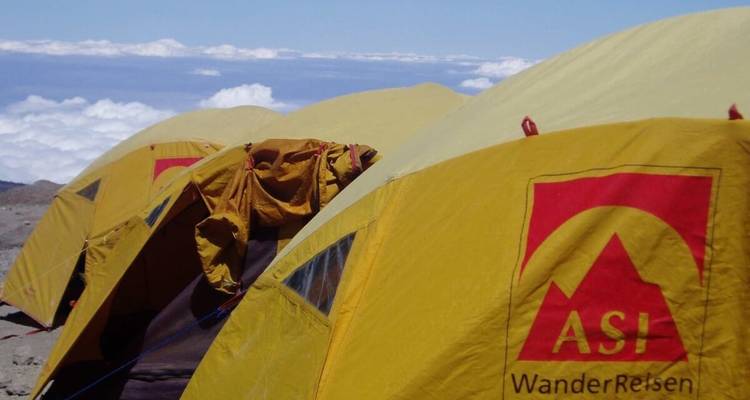 Close-up of tents with 'ASI WanderReisen' branding in a mountainous area.