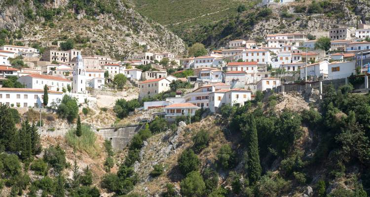 Hügeldorf mit weißen Gebäuden und roten Dächern.