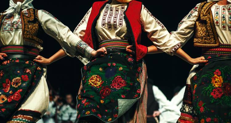 Traditionelle Outfits mit lebendigen Mustern und Farben in einem kulturellen Umfeld.