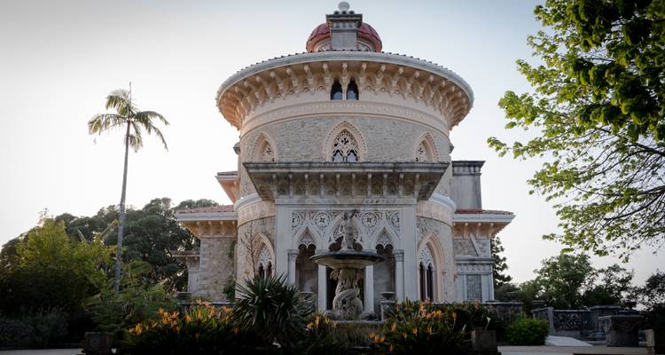 Historisch paleis met ingewikkelde architectuur omringd door groen.