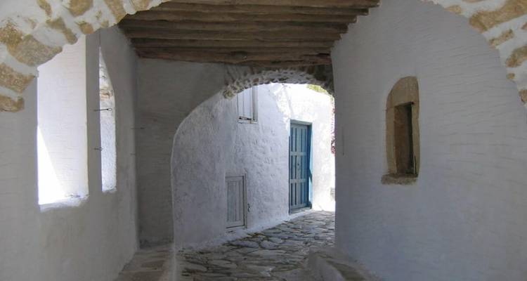 Une ruelle pittoresque et étroite avec des murs blanchis à la chaux et un sol en pierre.