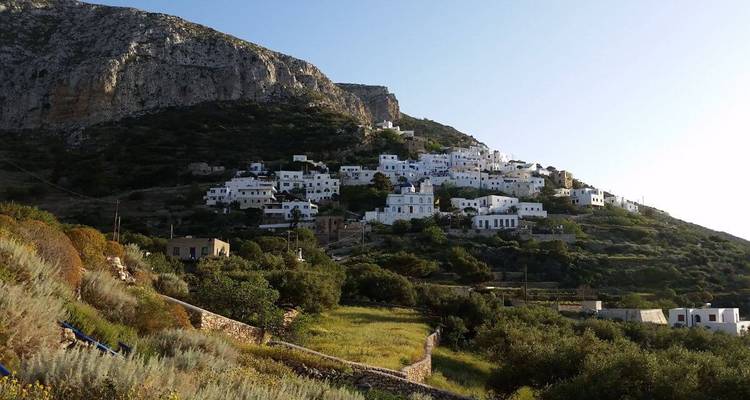 Un village blanc niché sur une colline au terrain rocheux.