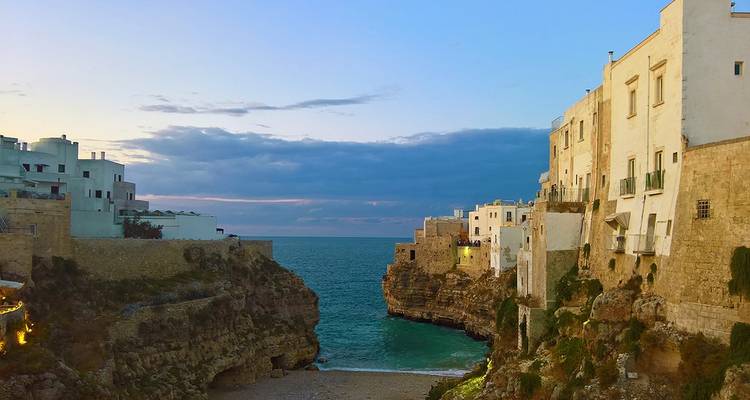Vista panorámica de edificios y el mar al atardecer.