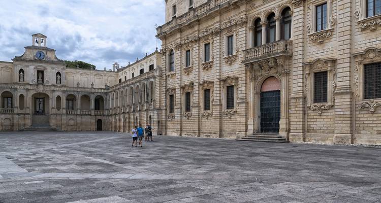 Gran palacio barroco con fachada intrincada en una plaza.