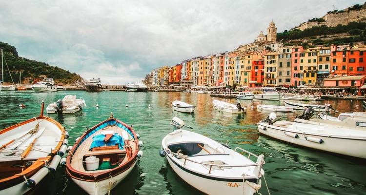 Bâtiments colorés et bateaux dans un port italien animé.