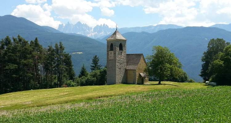Église en pierre avec un arrière-plan de montagnes.