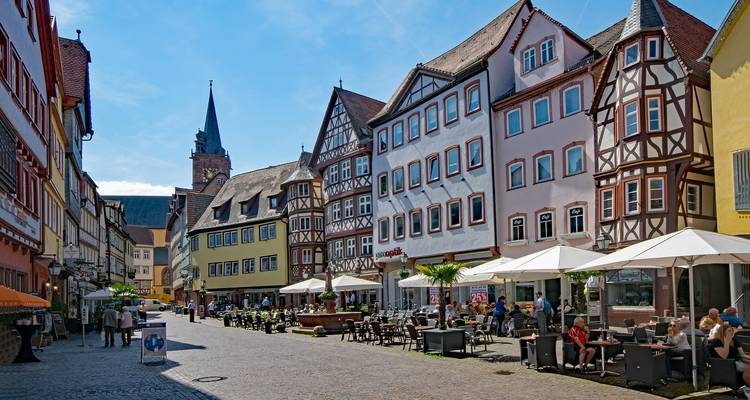 Straße gesäumt von Cafés und bunten Fachwerkhäusern.