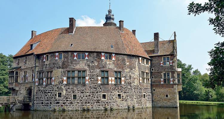 Alte Steinburg mit Wassergraben und gewölbter Brücke.