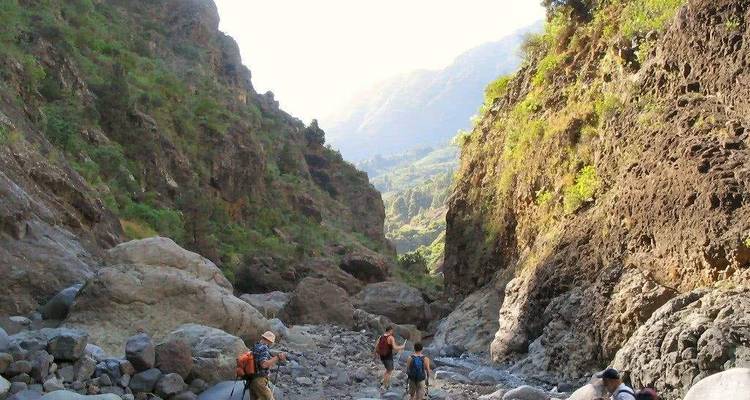 Gruppe von Wanderern, die durch eine felsige Schlucht gehen.