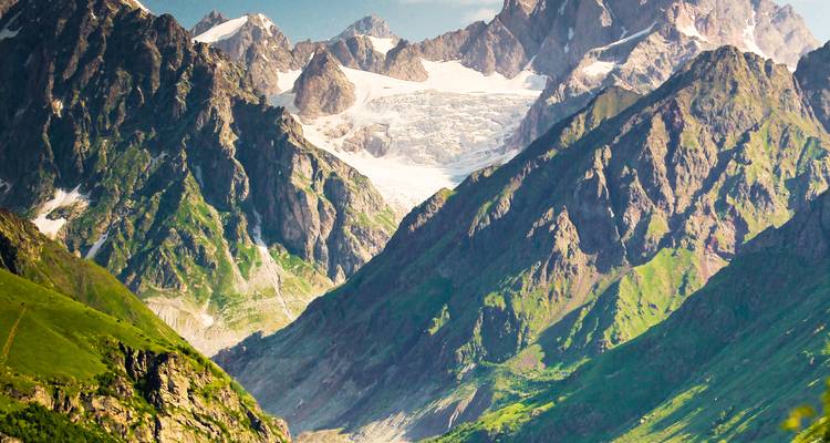 Montagnes enneigées avec un glacier entre des crêtes rocheuses.