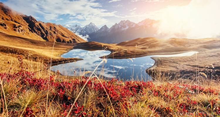 Vibrant autumn landscape with a lake reflecting mountains.