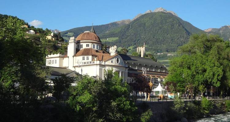 Elegant historic building with mountains in the background.