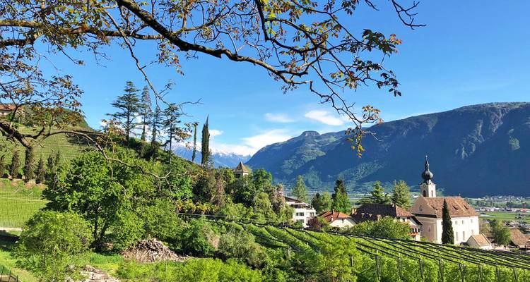 Vue panoramique d'une église et du paysage environnant avec des montagnes.