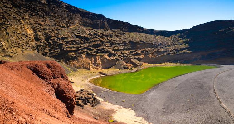 Lagon vert entouré de formations rocheuses volcaniques.