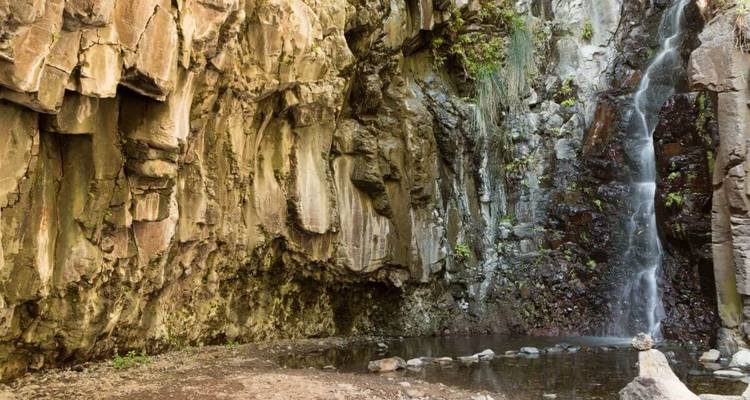 Chute d'eau en cascade le long de falaises rocheuses.