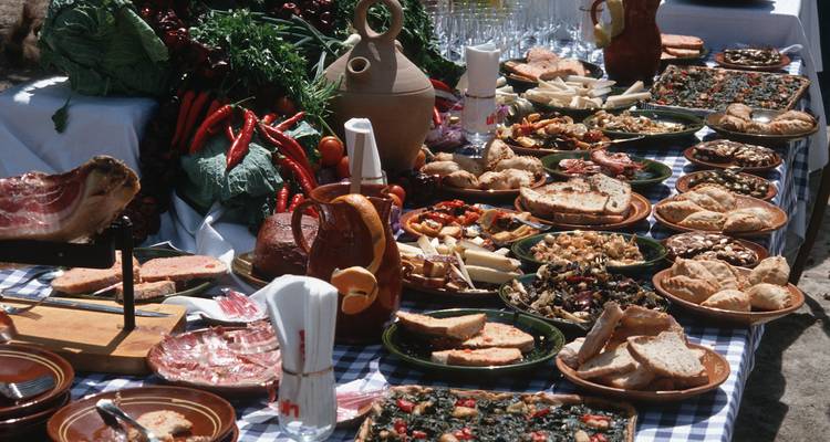 Assortiment traditionnel de plats méditerranéens sur une table en plein air.