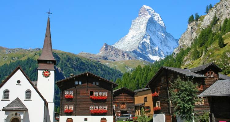 Village avec maisons traditionnelles et un sommet de montagne en arrière-plan.