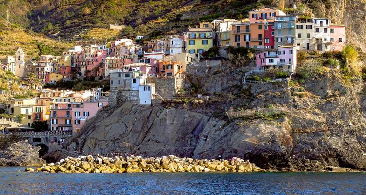 Colorful seaside homes perched on rocky cliffs.
