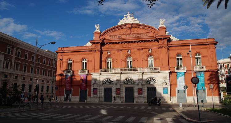 Theatergebouw met oranje gevel en blauwe lucht.
