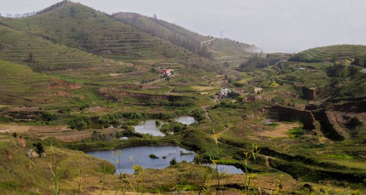 Paysage de vallée avec plusieurs petits étangs et collines.