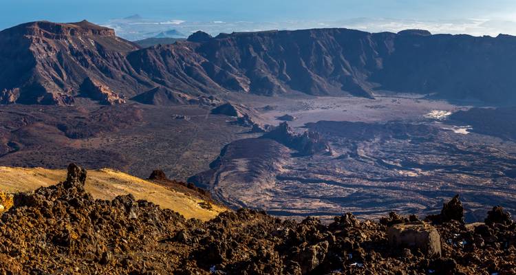 Vue aérienne d'un vaste paysage volcanique et montagneux.
