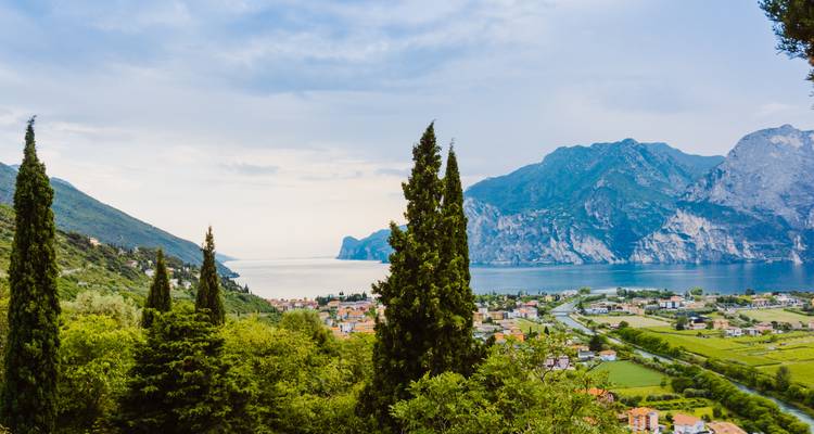 Malerische Aussicht auf einen See, umgeben von Bergen und Grün.