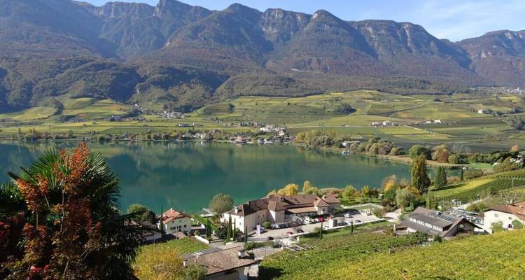 Lake view with fields and mountains under a clear sky.
