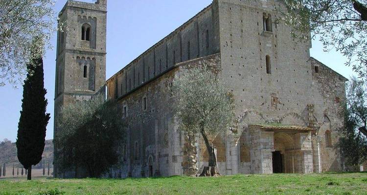 Abbaye historique entourée d'arbres sous un ciel lumineux.