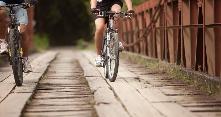 Deux personnes à vélo sur un pont de planches.