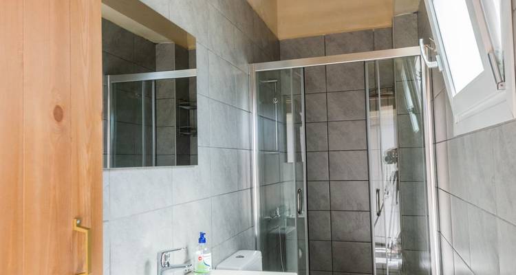 Badezimmer-Interieur mit Dusche und gefliesten Wänden.