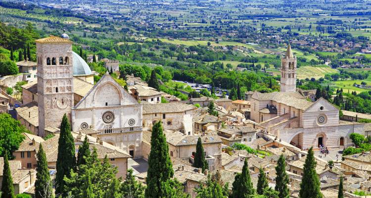 Vue aérienne d'Assise avec des églises et des collines ondulantes.