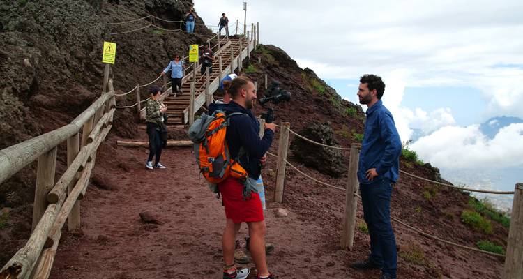 Groupe de personnes faisant de la randonnée sur un sentier de montagne dans un environnement brumeux.